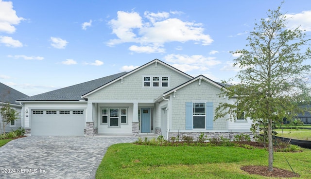 craftsman-style home featuring a garage and a front lawn