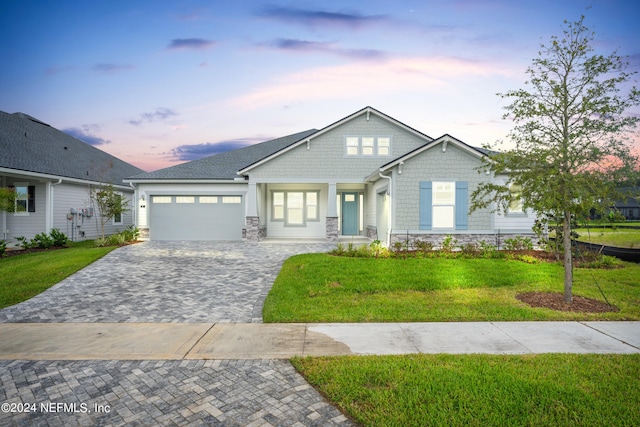 view of front of property with a garage and a yard