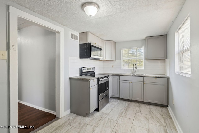 kitchen featuring gray cabinetry, sink, tasteful backsplash, and appliances with stainless steel finishes