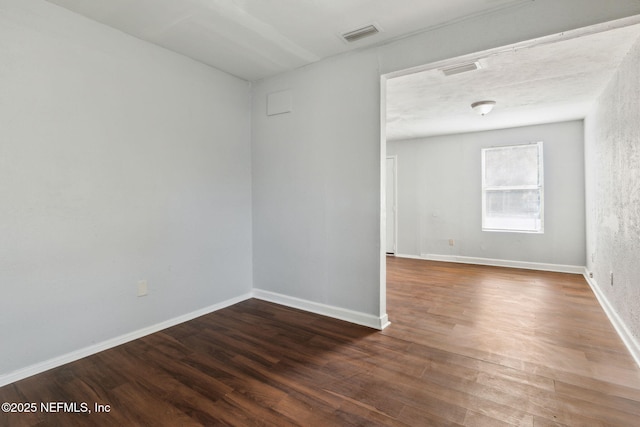 unfurnished room with dark wood-type flooring