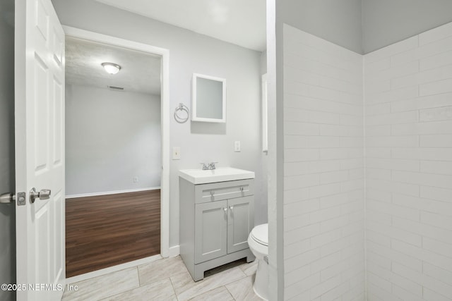 bathroom featuring vanity, hardwood / wood-style floors, and toilet