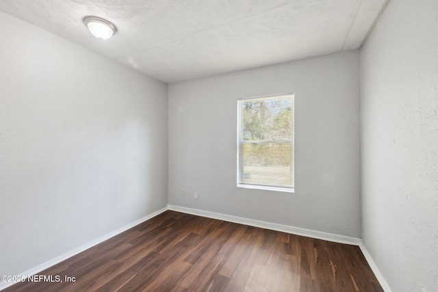 unfurnished room with dark wood-type flooring