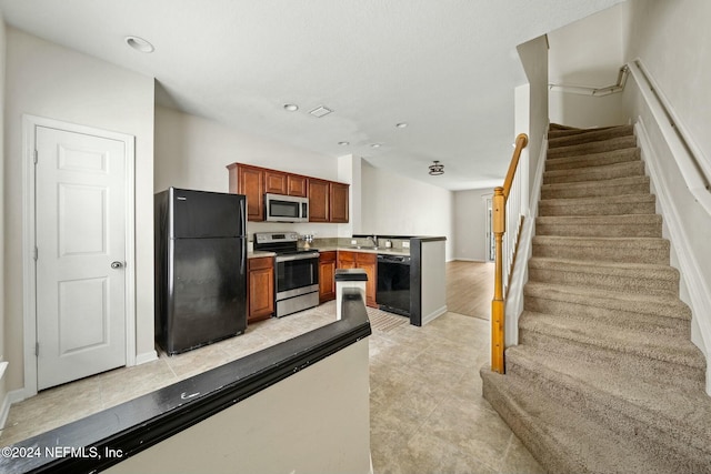 kitchen with light tile patterned floors, sink, and black appliances