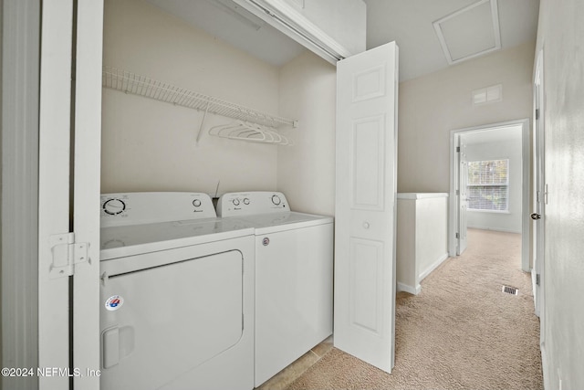 laundry area with washing machine and dryer and light colored carpet