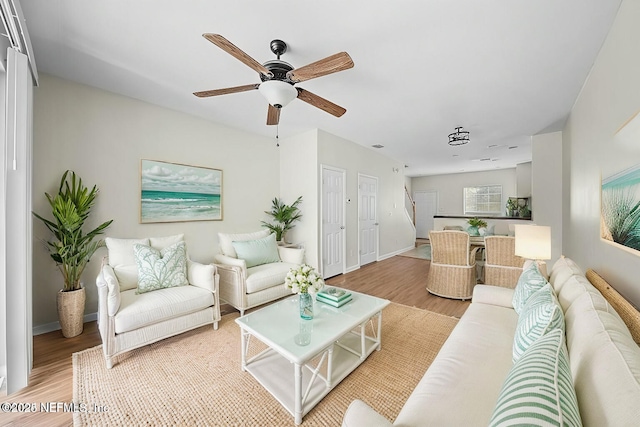 living room featuring ceiling fan and light hardwood / wood-style floors