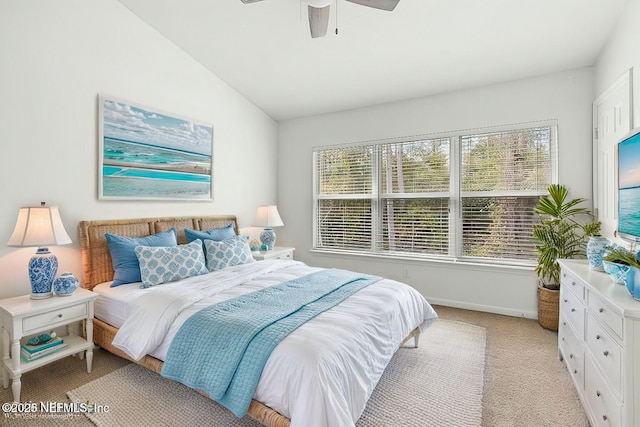 bedroom featuring multiple windows, vaulted ceiling, light colored carpet, and ceiling fan