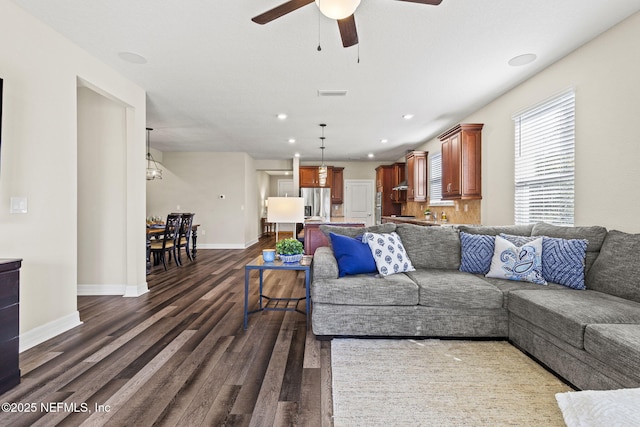 living room with dark wood-type flooring and ceiling fan