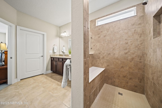 bathroom with vanity, a textured ceiling, and a tile shower