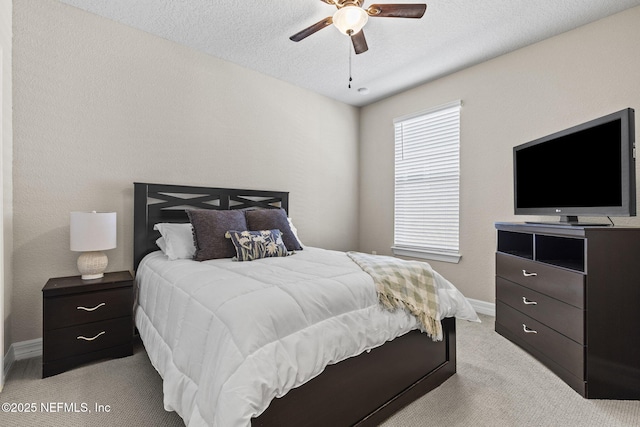 carpeted bedroom with ceiling fan and a textured ceiling