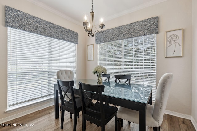 dining space featuring hardwood / wood-style flooring, ornamental molding, and a notable chandelier