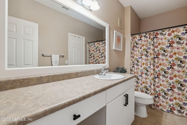 bathroom with tile patterned flooring, vanity, and toilet