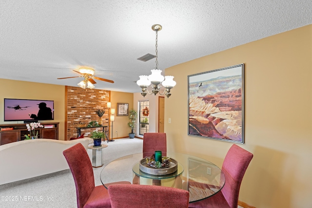 dining area featuring carpet, ceiling fan with notable chandelier, and a textured ceiling