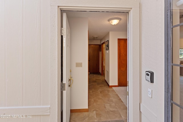 hall with a textured ceiling