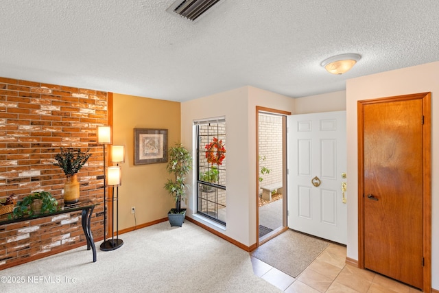 foyer featuring light carpet and a textured ceiling