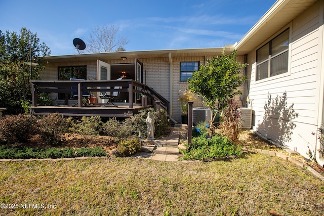 exterior space featuring central AC unit, a front lawn, and a deck