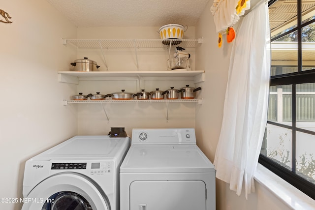 washroom with washer and clothes dryer and a textured ceiling