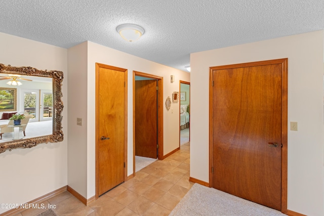 hallway featuring a textured ceiling and light tile patterned floors