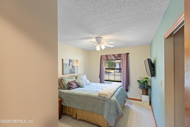 carpeted bedroom featuring ceiling fan and a textured ceiling