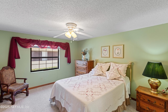 bedroom with ceiling fan, light colored carpet, and a textured ceiling