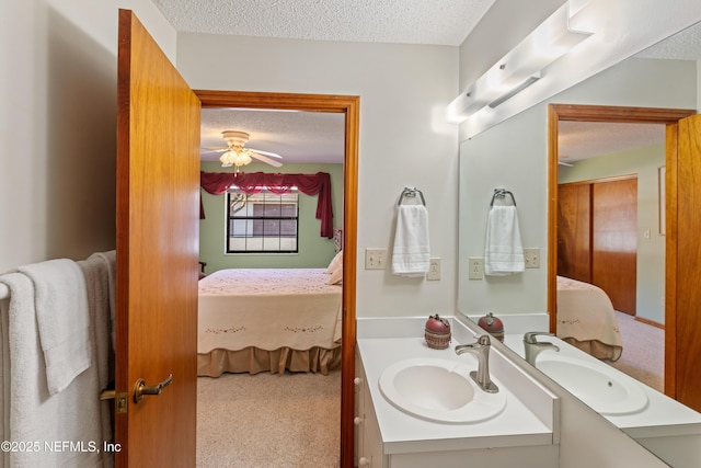 bathroom with vanity, ceiling fan, and a textured ceiling