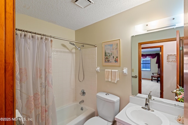 full bathroom featuring vanity, shower / tub combo, a textured ceiling, and toilet