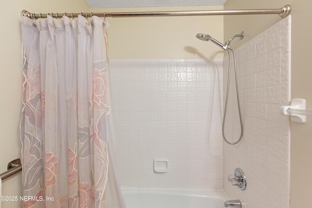 bathroom with shower / bathtub combination with curtain and a textured ceiling