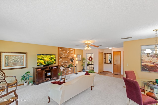 carpeted living room featuring ceiling fan with notable chandelier and a textured ceiling