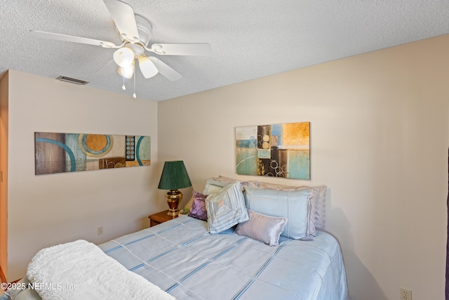 bedroom with a textured ceiling, ceiling fan, and visible vents