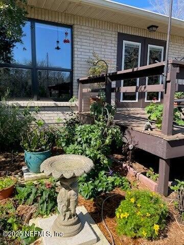 exterior space featuring a wooden deck and brick siding