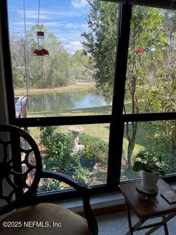 sunroom / solarium featuring a water view