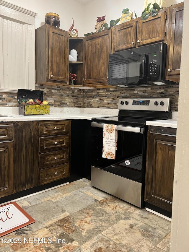 kitchen with light countertops, stone finish floor, dark brown cabinets, black microwave, and stainless steel electric range