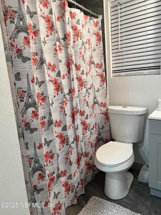 bathroom featuring toilet, curtained shower, and vanity