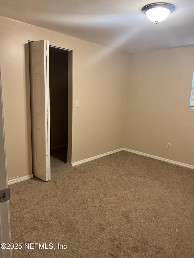 spare room with carpet flooring and baseboards