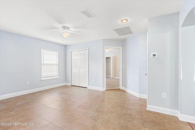 unfurnished bedroom featuring ceiling fan, a closet, and a textured ceiling