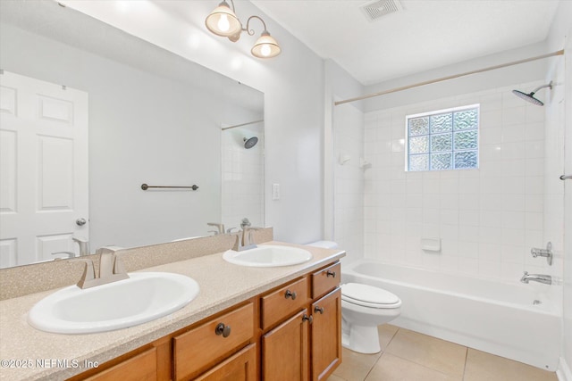 full bathroom with tile patterned floors, toilet, tiled shower / bath combo, and vanity