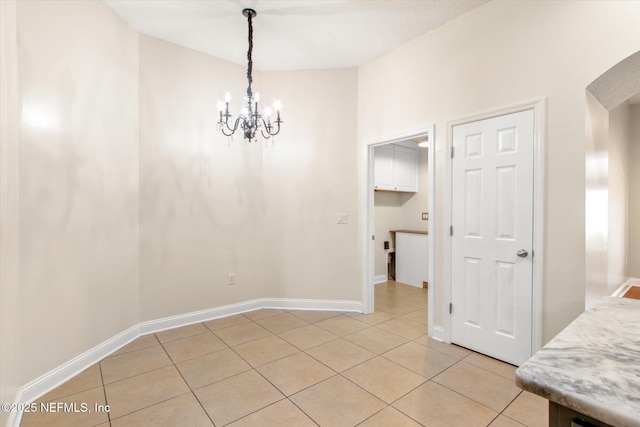 tiled dining room with a notable chandelier