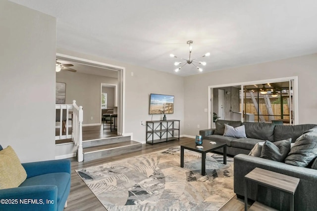 living room featuring ceiling fan with notable chandelier and hardwood / wood-style floors