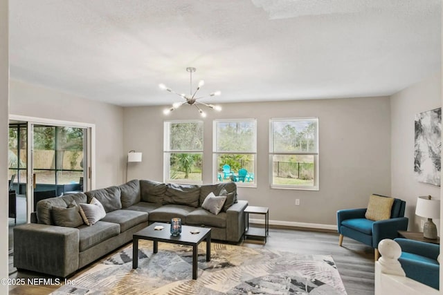 living room with wood-type flooring, a chandelier, and a textured ceiling