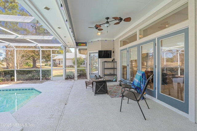 view of swimming pool featuring a lanai, ceiling fan, and a patio area