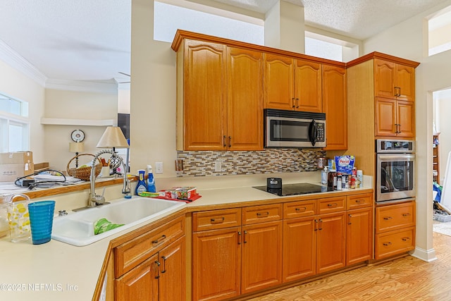 kitchen with sink, crown molding, a textured ceiling, stainless steel appliances, and backsplash