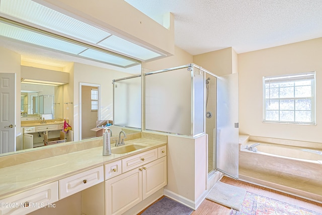 bathroom featuring vanity, separate shower and tub, and a textured ceiling