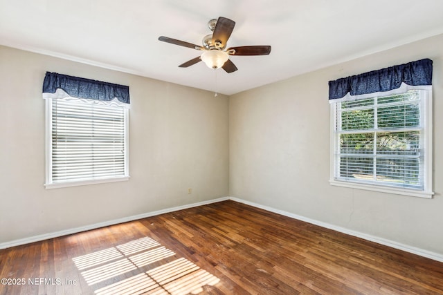 empty room with ceiling fan, wood finished floors, and baseboards