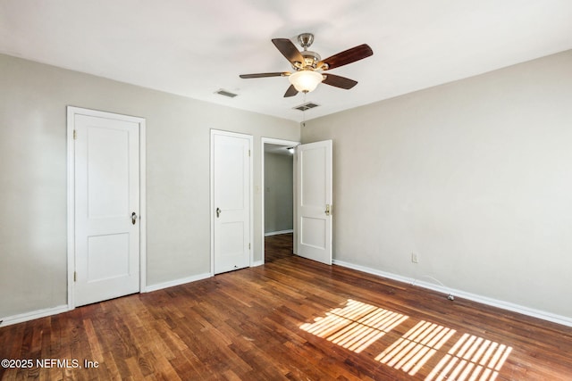 unfurnished bedroom featuring visible vents, baseboards, and wood finished floors