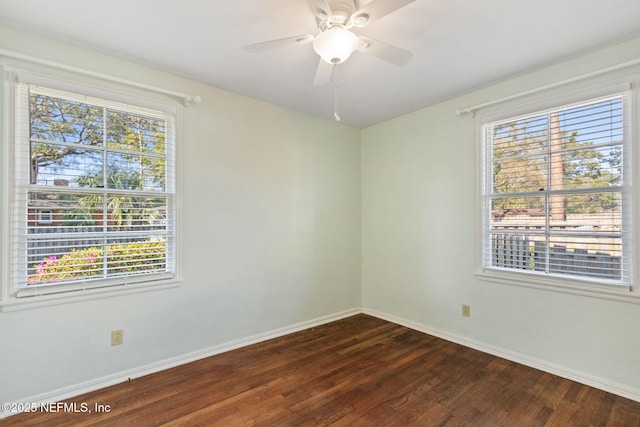 empty room featuring dark wood-style floors, ceiling fan, and baseboards