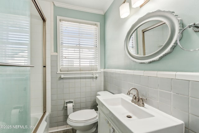 full bathroom featuring toilet, tile walls, vanity, tub / shower combination, and crown molding