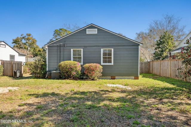 view of property exterior featuring fence, central AC, and a yard