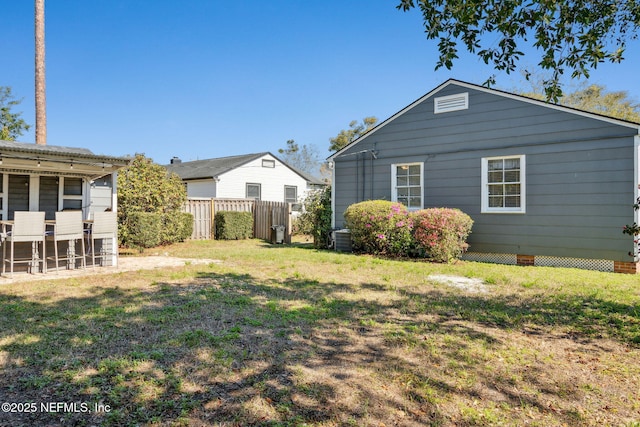 exterior space with a yard, central AC, and fence