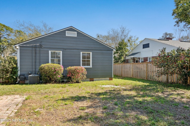 exterior space featuring fence, central AC unit, and a yard