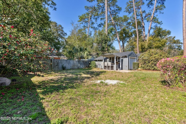 view of yard featuring fence and an outdoor structure