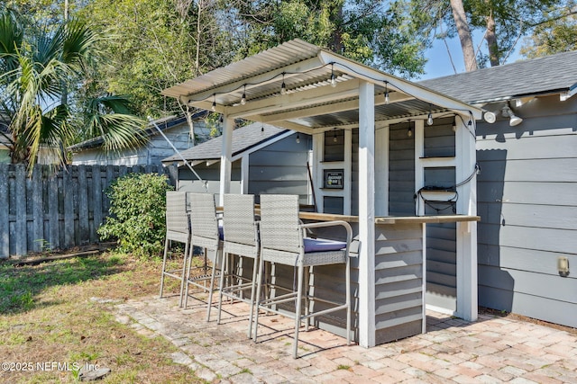 view of patio with fence and outdoor dry bar